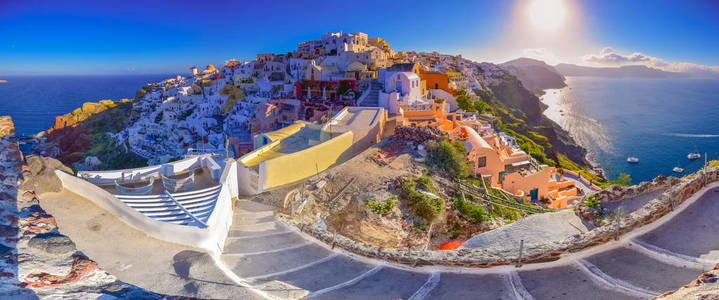 希腊圣托里尼岛伊亚镇。传统和著名的房子和教堂与蓝色圆顶上的火山口，爱琴海