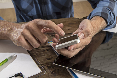 身份不明的男子紧手使用手机工作忙着记事本和数字平板电脑平板电脑