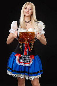 年轻的女人穿裙与黑色背景上的两个啤酒杯子。
