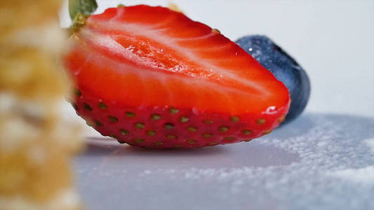 草莓和蓝莓蛋糕的白板上。草莓和蓝莓在白色的碗