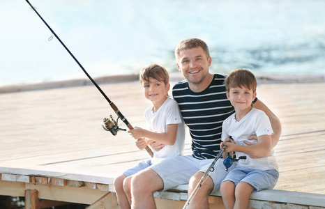 父亲与儿子钓鱼从码头在河