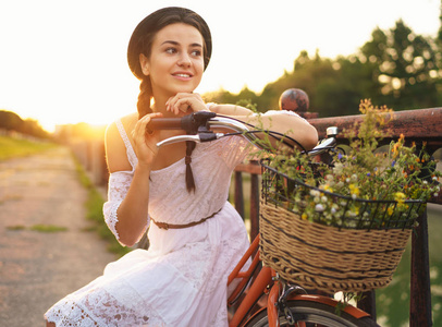 年轻漂亮的女人，坐在她的自行车在太阳花