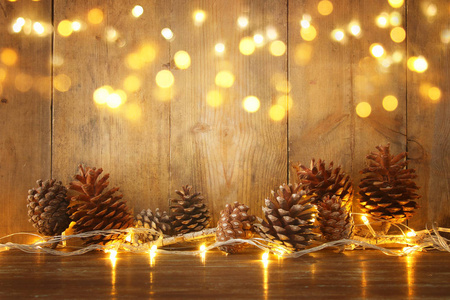 节日图像与圣诞金色花环灯和松果在木制的背景