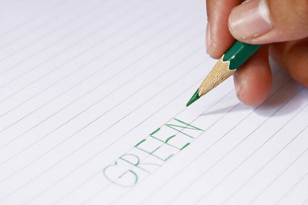 绿色的铅笔，在模糊的人的手