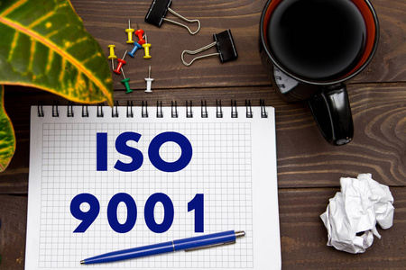 与笔记 Iso 9001 与工具的办公室桌上的笔记本。B