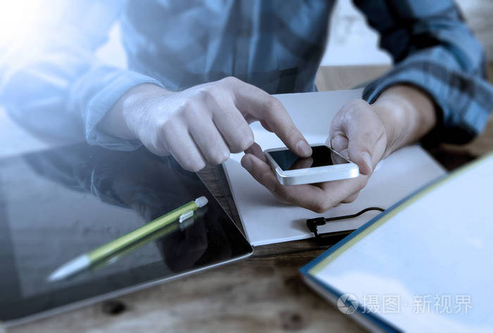 身份不明的男子紧手使用移动电话和工作忙照片-正版商用图片0zgf1g-摄