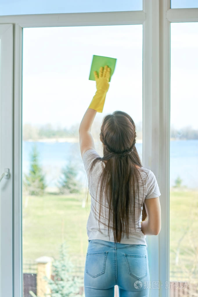 用破布擦窗户的女孩