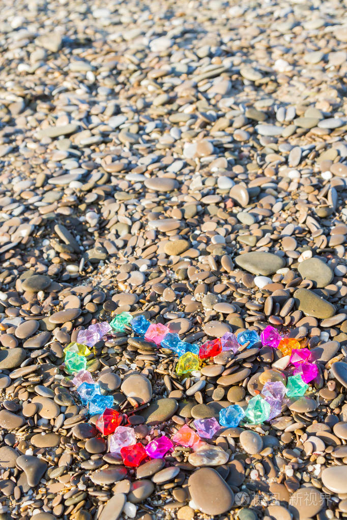 海岸边玻璃鹅卵石的鲜艳的心