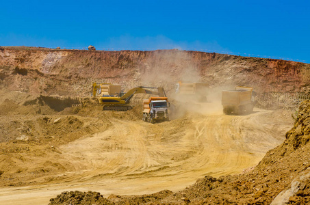 挖掘机及在采石场采矿的卡车图片