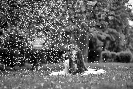 在与花瓣互生的绿色草地上的小女孩