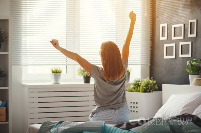 年轻女子在早晨醒来在卧室的窗照片-正版商用图片0zh8kb-摄图新视界