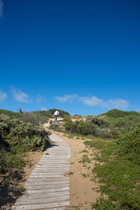 女人徒步翻越沙丘在 Coorong 国家公园