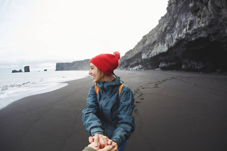 走在 Kirkjufjara 黑沙海滩，冰岛南部的女人