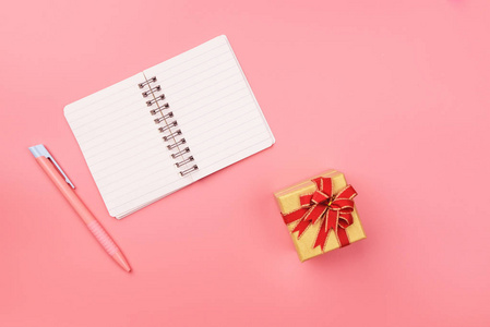 用笔及礼品盒粉红色柔和桌面上的空白笔记本