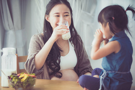 亚洲家庭幸福妈妈和女儿喝牛奶