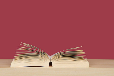 站起来的书翻开的书页站起来躺在红色背景上的 bookplank照片