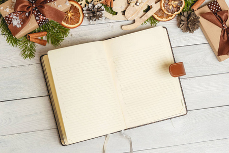 圣诞饰品和光的木桌子上打开空白笔记本