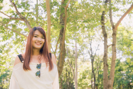 享受着大自然。年轻的亚洲女人双臂上举享受着新鲜的空气，在绿色的森林