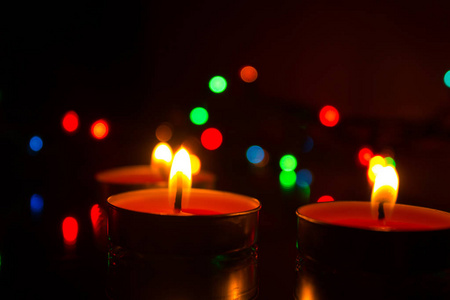 在黑暗的背景上，蜡烛由蜡和花环制成