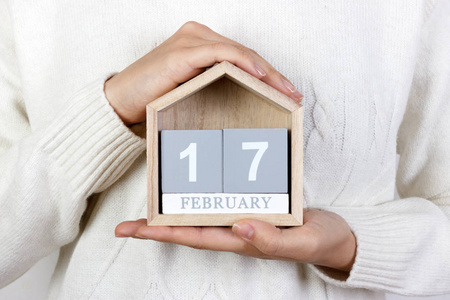 2 月 17 日在日历中。女孩拿着一个木制的日历。随机行为的仁慈的一天