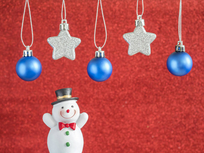 银色星和蓝色圣诞球挂在红色模糊背景