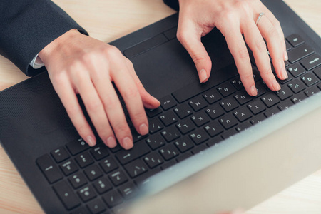 女性的手都在笔记本电脑键盘上打字