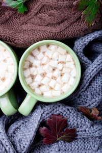 两杯咖啡或热巧克力和果汁软糖附近三针织灰色 黑色和棕色毛衣或针织毯子。秋天的概念。圣诞节。顶视图。在家里的温暖