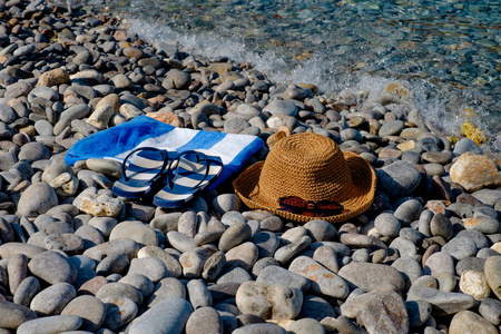 那顶草帽，太阳镜，拖鞋，毛巾上背景海景