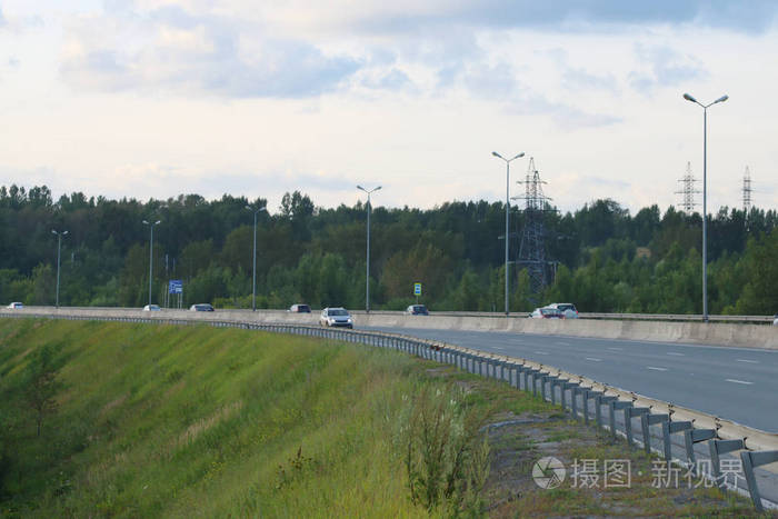 许多现代汽车在现代公路与灯笼上移动在夏天