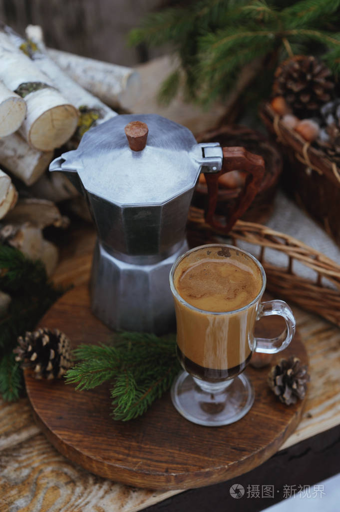 咖啡壶和一杯咖啡与圣诞装饰品桌上