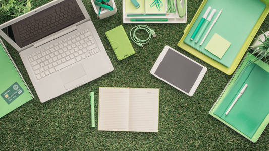 笔记本电脑和办公用品在草地上