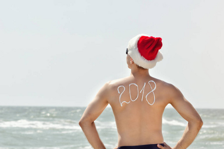 圣诞老人的帽子与碑文 2018年回来站在海滩上的人