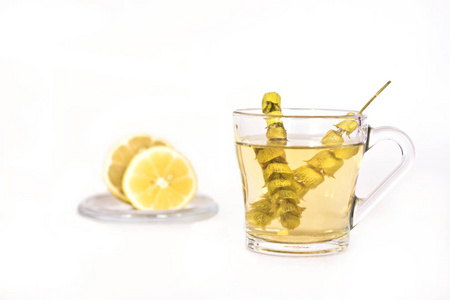 鼠尾草和柠檬放在玻璃杯子里的热奶茶