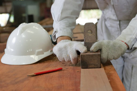 工人刨木工车间里用手刨一块木板的手