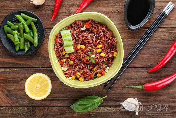 碗糙米饭和木制的桌子上的蔬菜