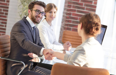 经理的握手和办公室中的客户端照片