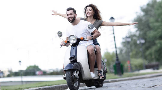 幸福的夫妇驾驶摩托车在暑假假期兴奋