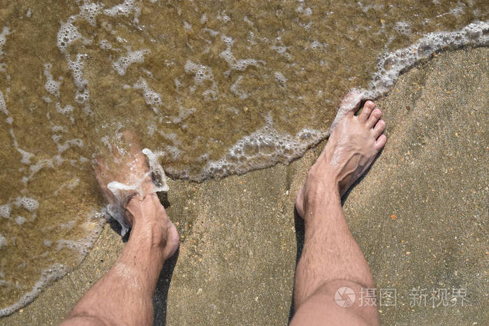 腿人在海沙子附近海浪