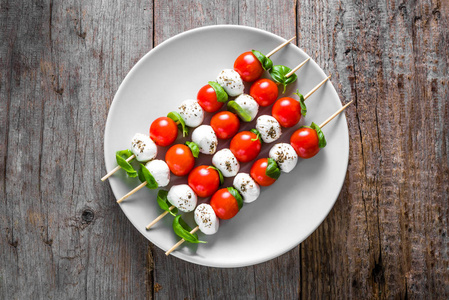 健康的开胃菜凯普莱斯沙拉配番茄和马苏里拉，意大利菜的地中海饮食橄榄油调味，重量损失概念