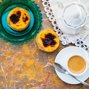 设想与早上喝咖啡和蛋糕 Pasteis de 椰果，来自葡萄牙的典型糕点，天然大理石表面上