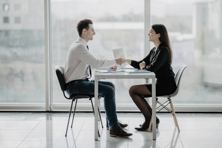 谈判合作友好微笑的商人和女商人握手在办公桌后愉快的谈话和有效谈判