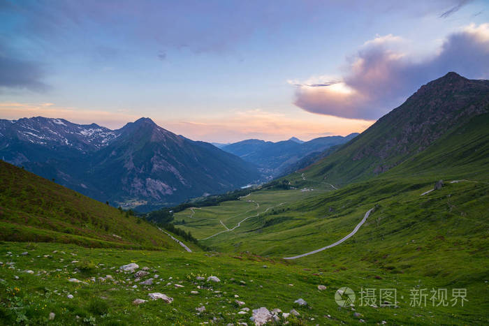 通往高山关隘上意大利阿尔卑斯山的山路。南昆线膨胀看日落 多彩戏剧性的天空，在夏天冒险客场之旅