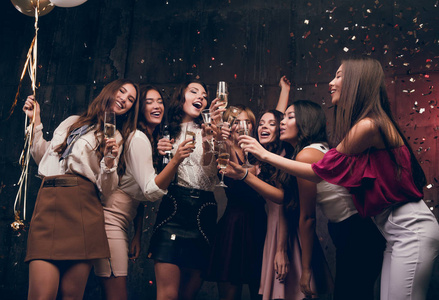女孩许新年愿望，喝香槟。快乐一群有吸引力的女孩与香槟共舞