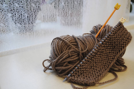 一丛丛的毛线和编织针在桌子上图片