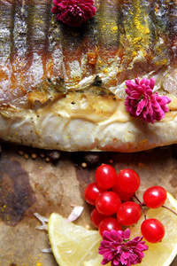 烤鱼与奶酪 蜂蜜 罗文 纳 柠檬片，烤土豆，粉红色的花朵和羊皮纸上的香料