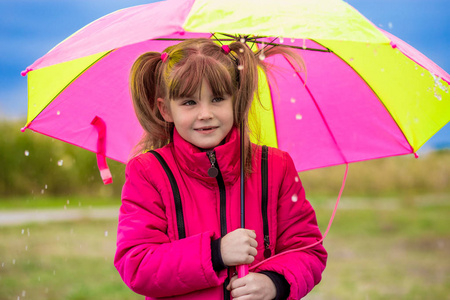 五颜六色的伞在花园里玩有趣可爱的小女孩