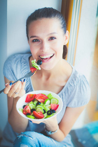 一个漂亮的女孩吃健康的食物。漂亮女孩