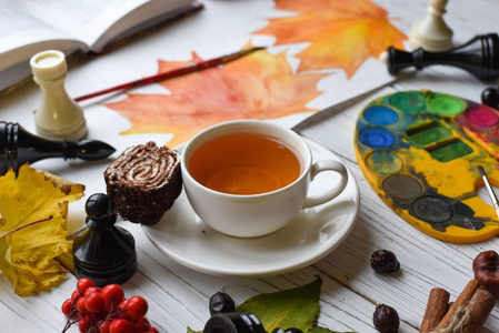 一杯茶 水彩 绘图 一本书，秋天的落叶和肉桂棒温馨合影