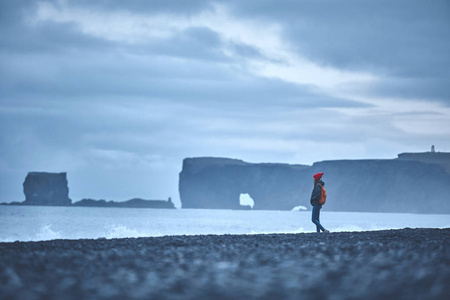 走在 Reynisfjara 黑沙海滩，冰岛南部的女人