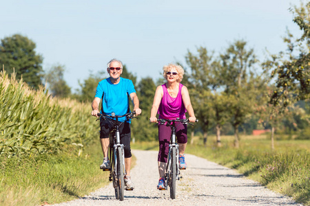 积极的老年夫妇享受退休, 而骑自行车我